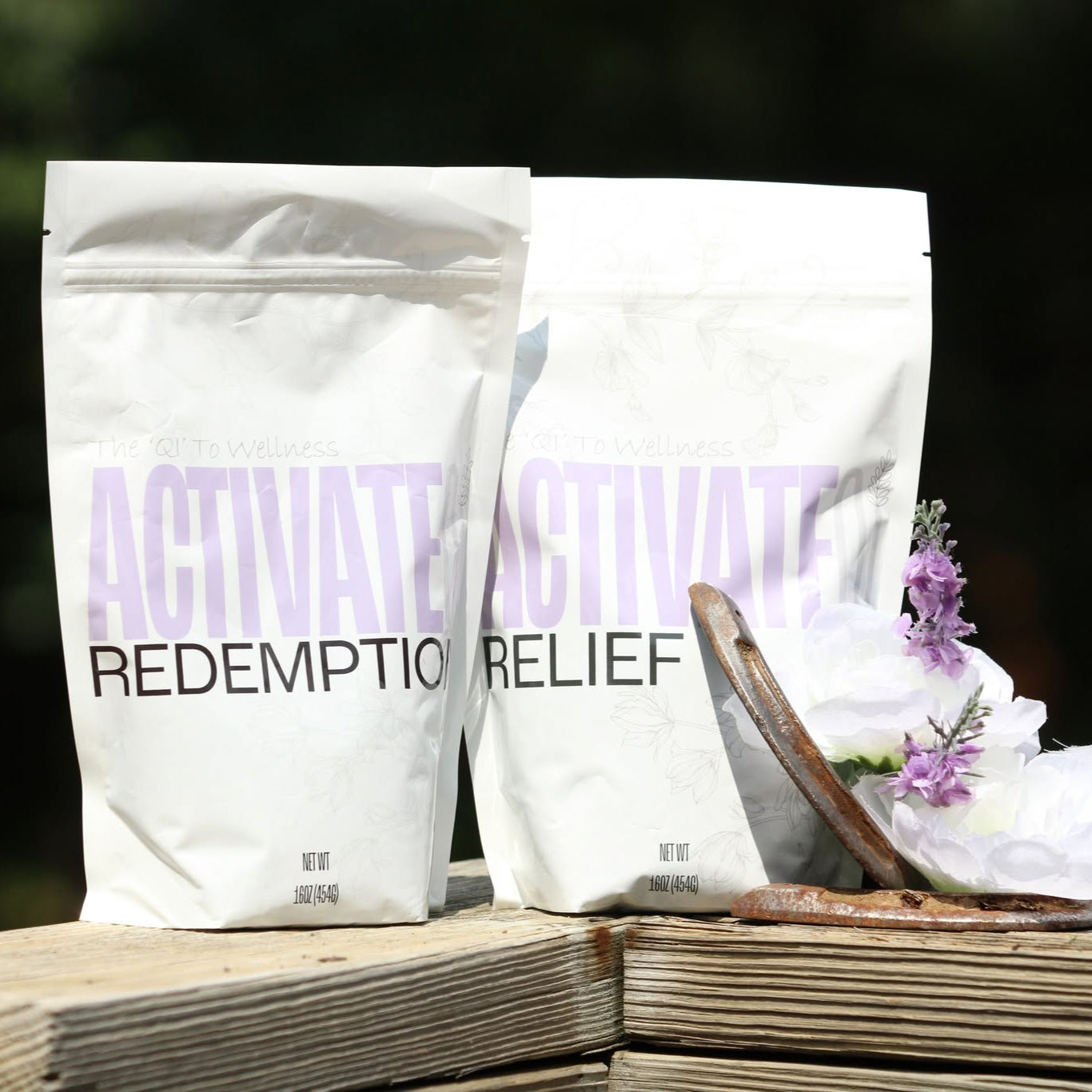 Two white bags labeled ActivateQi with a blurred natural background