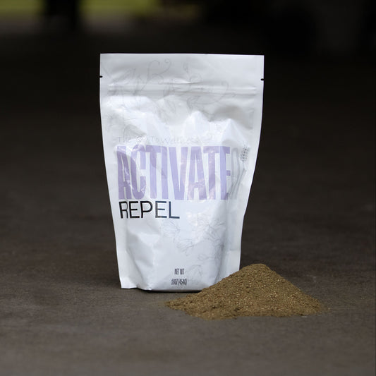 White bag labeled ACTIVATEQI REPEL with a small pile of herbal powder on a dark background